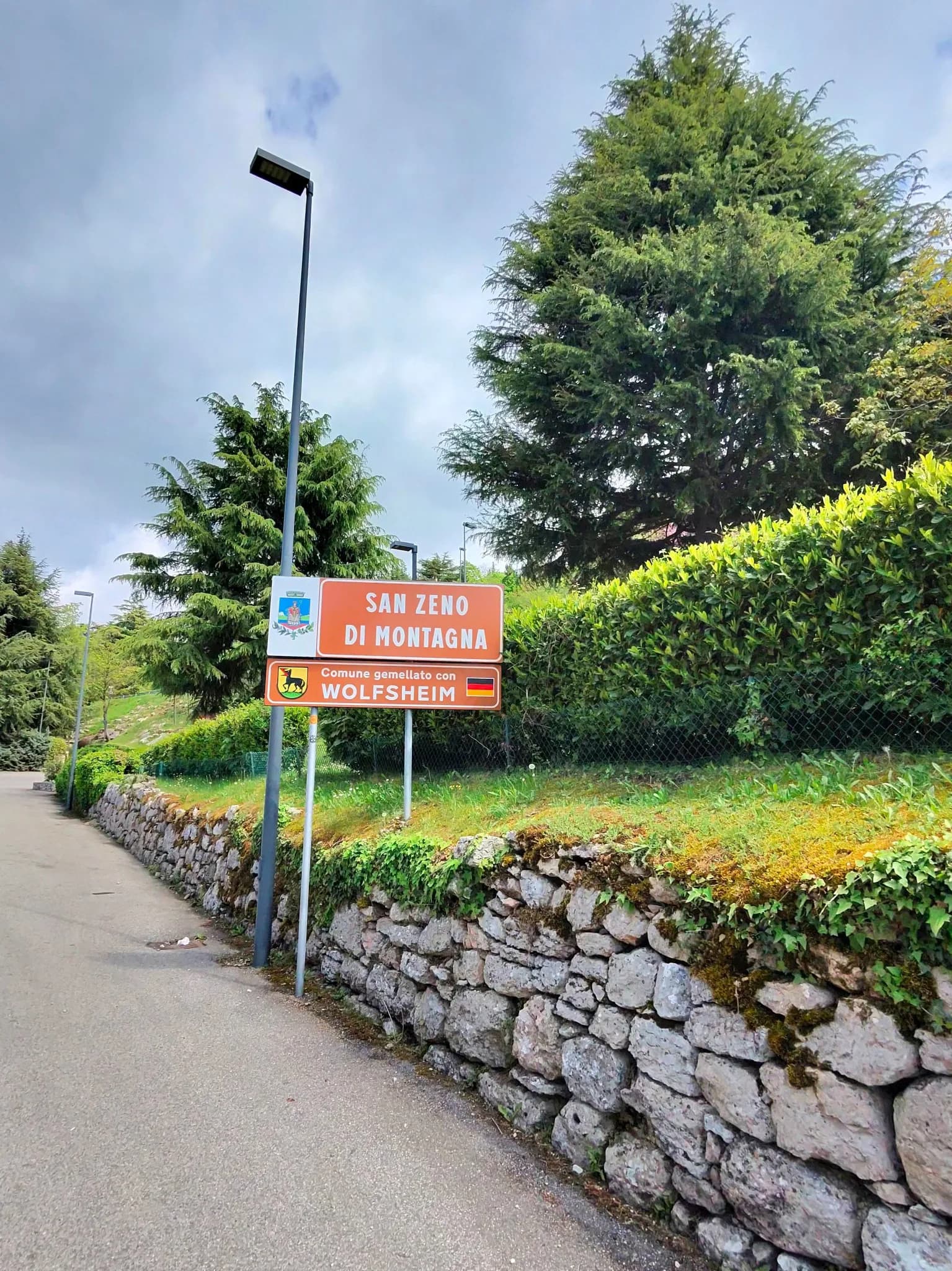 Знак San Zeno di Montagna у каменной стены